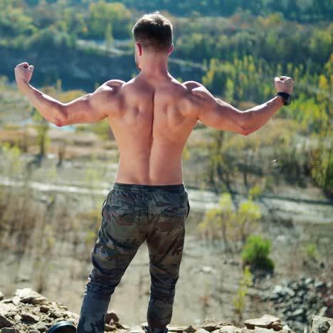 . handsome sportsman outdoors. rear view of muscular man posing on nature
