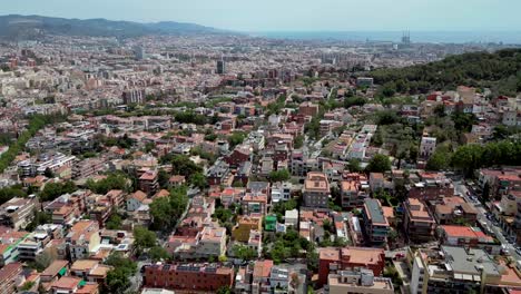 an aerial drone shots of catalonia skyline with green trees and pyrenees in the background