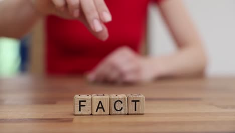 spelling the word fake with wooden letter blocks