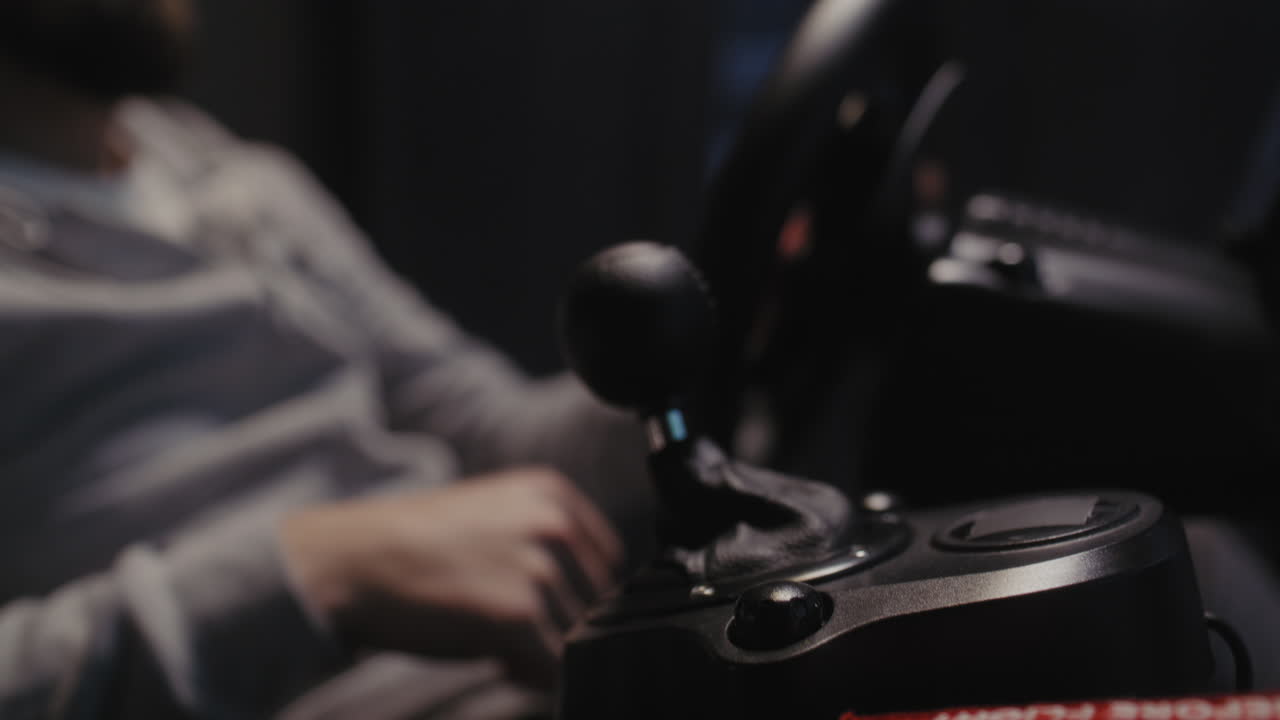 Person som bruker et racerratt og girspak i en racingsimulator