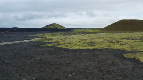 drone flyover black volcanic lava field with green surroundings in hawaii, 4k