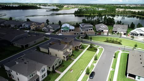 vista aérea de una subdivisión de barrio de clase media alta frente al lago con casas unifamiliares y casas adosadas, piscina y casa club en un día nublado de otoño en el jardín de invierno, florida, ee.uu.