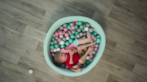 blond boy has fun lying in dry pool with elder sister