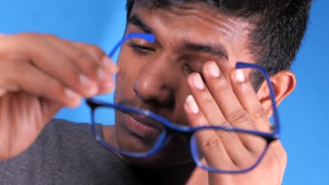 young man adjusting glasses, possible eye strain