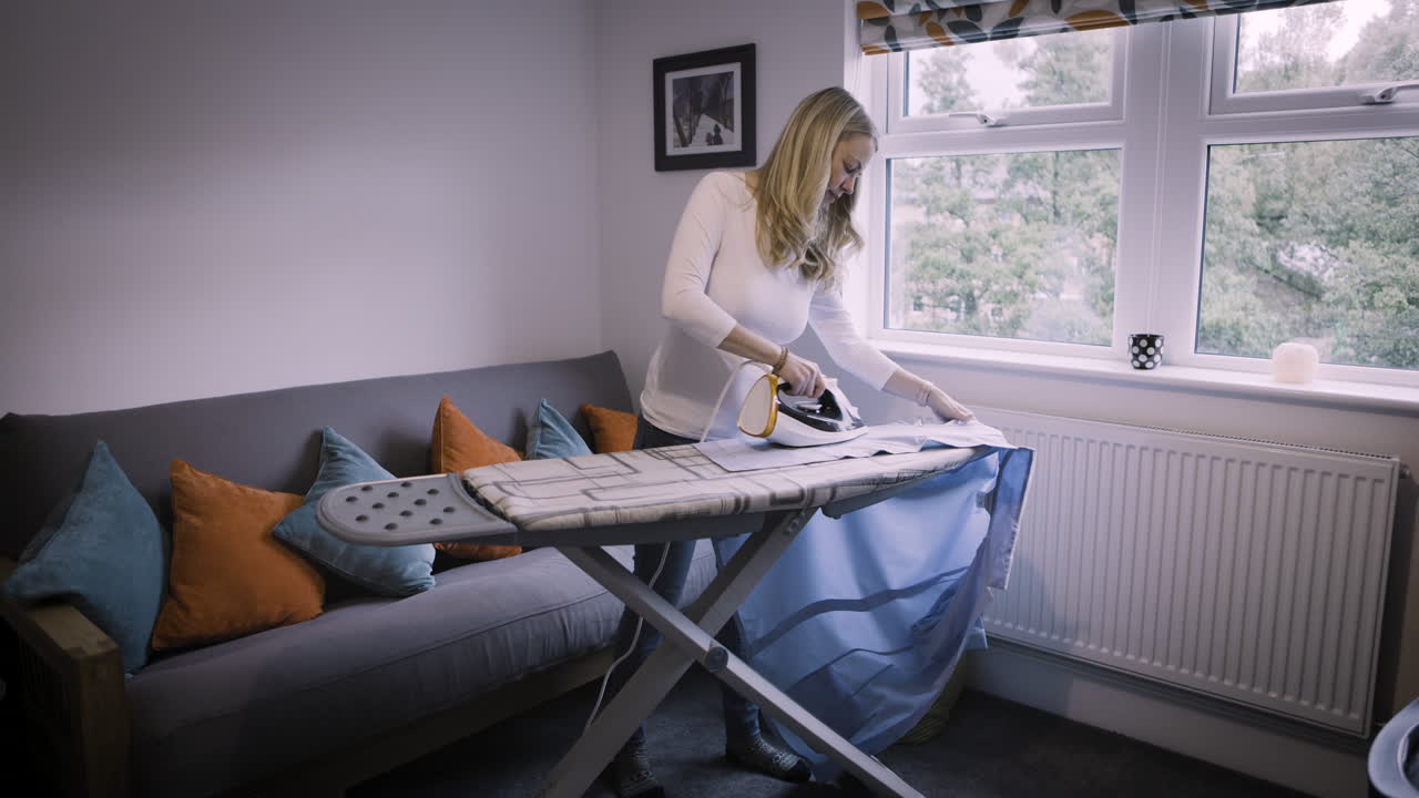 Woman ironing clothes at home