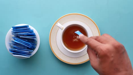 Sugar-substitute-sweetener-in-a-packet-and-cup-of-tea-on-table