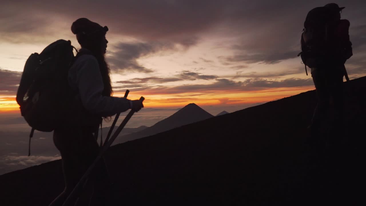 Hikers in the sunrise walking up a mountain in slow motion