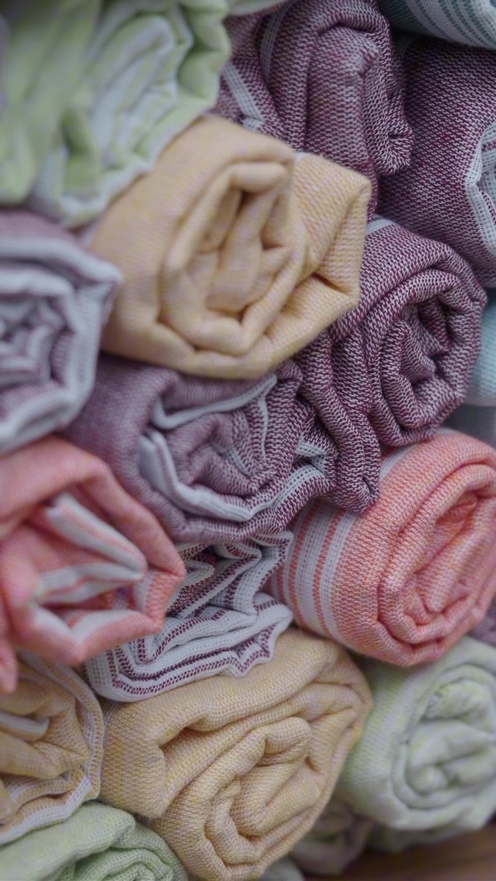 Close-up of Stacked Rolled Pastel Striped Towels