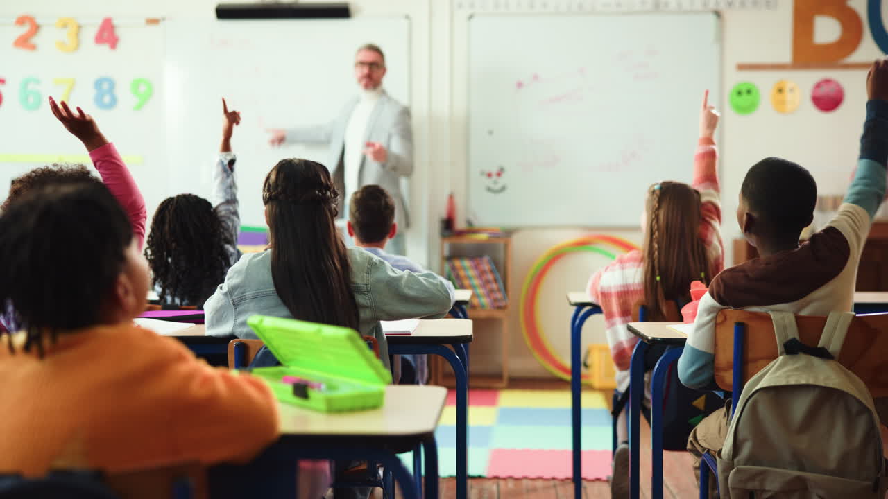 Classroom scene with students raising hands and a teacher