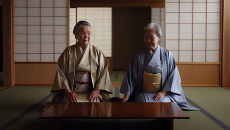 two elderly japanese women in traditional kimonos sitting in a tatami room