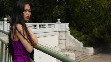 pretty asian woman standing on a bridge arms crossed looking tired and worried - slow motion