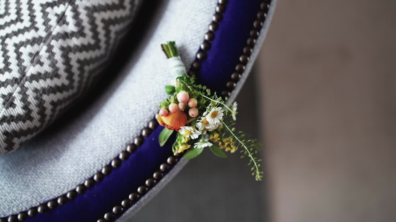 elegante boutonniere en una silla estampada, con flores frescas y vegetación