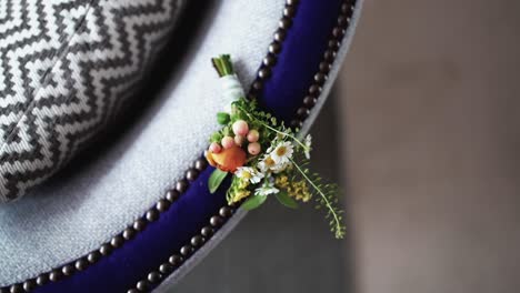 Boutonniere-Elegante-Sobre-Una-Silla-Estampada,-Con-Flores-Frescas-Y-Vegetación