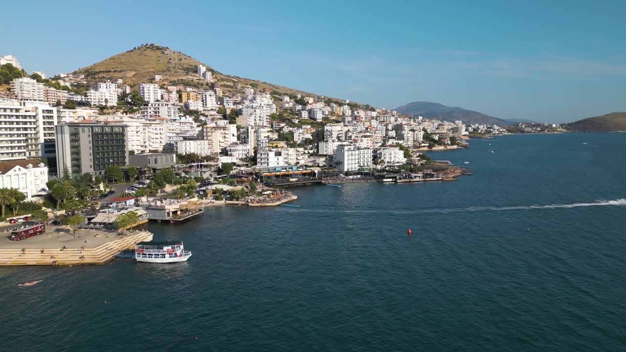 el dron desciende mientras las carreras de jet ski salen de la imagen en saranda, albania