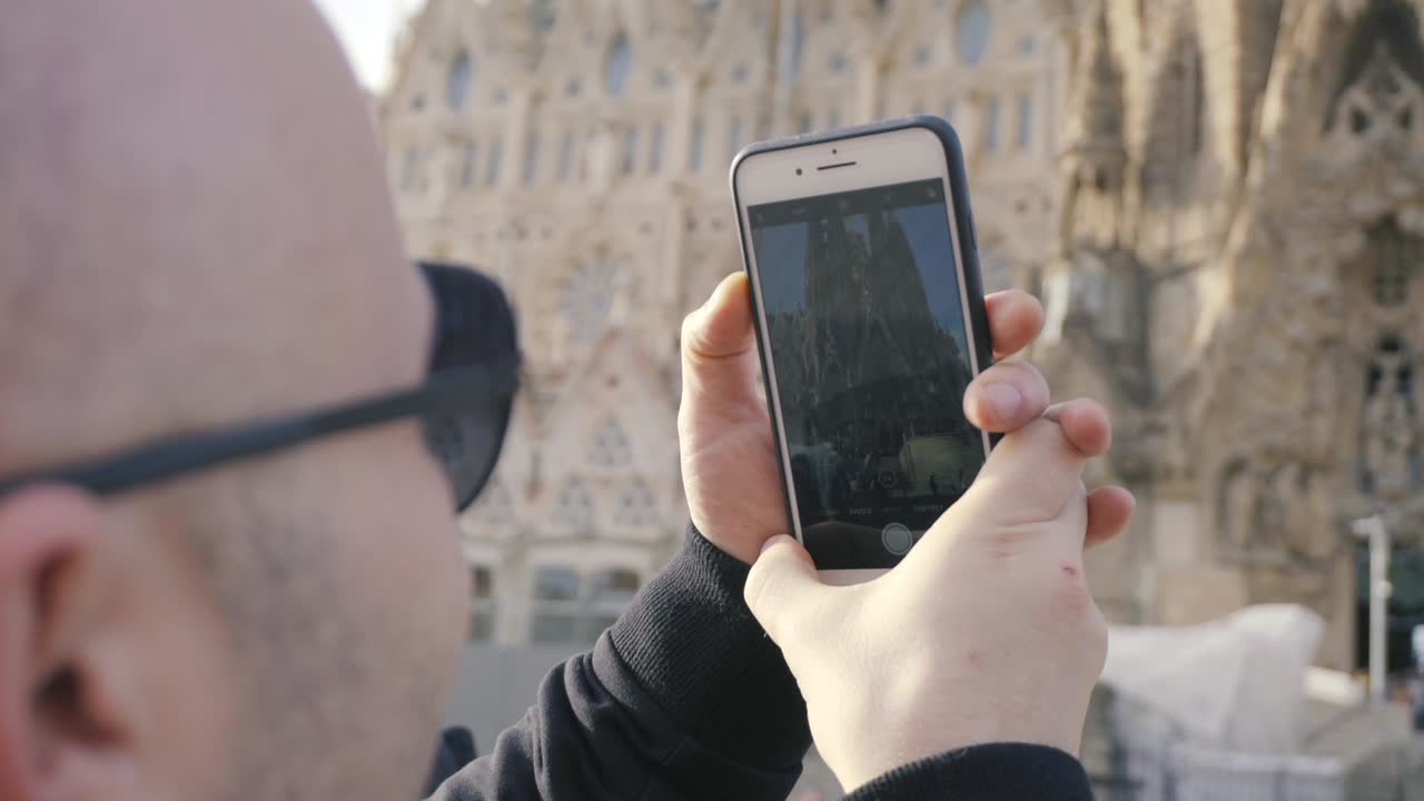 hombre tomando una foto de la sagrada familia en barcelona