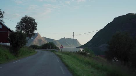 Fahren-Auf-Der-Asphaltstraße-Am-Seeufer-In-Der-Nähe-Des-Dorfes-Flakstad-Auf-Der-Insel-Senja,-Norwegen