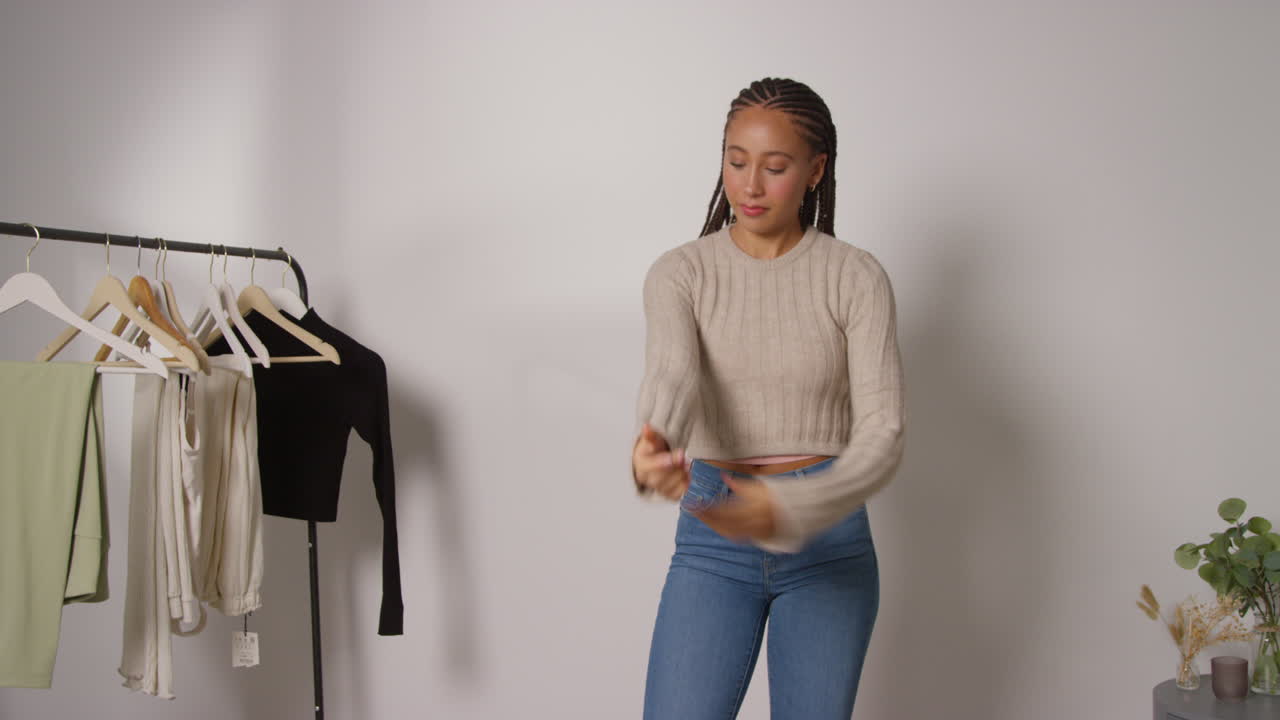 Female Social Media Influencer Producing User Generated Content In Studio Trying On A Variety Of Fashion Outfits Shot In Real Time 4