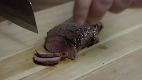 chef slicing roasted beef on a wooden cutting board during the cooking process, cafe de paris butter