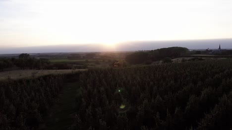 A-drone-shot-flying-to-the-side,-seeing-a-see-through-church-with-the-sunsetting-behind-it,-keeping-it-in-the-middle