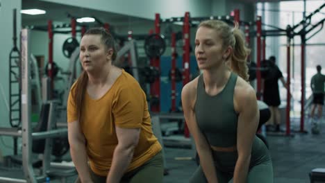 mujer caucásica con sobrepeso entrenando con un instructor de fitness en el gimnasio.