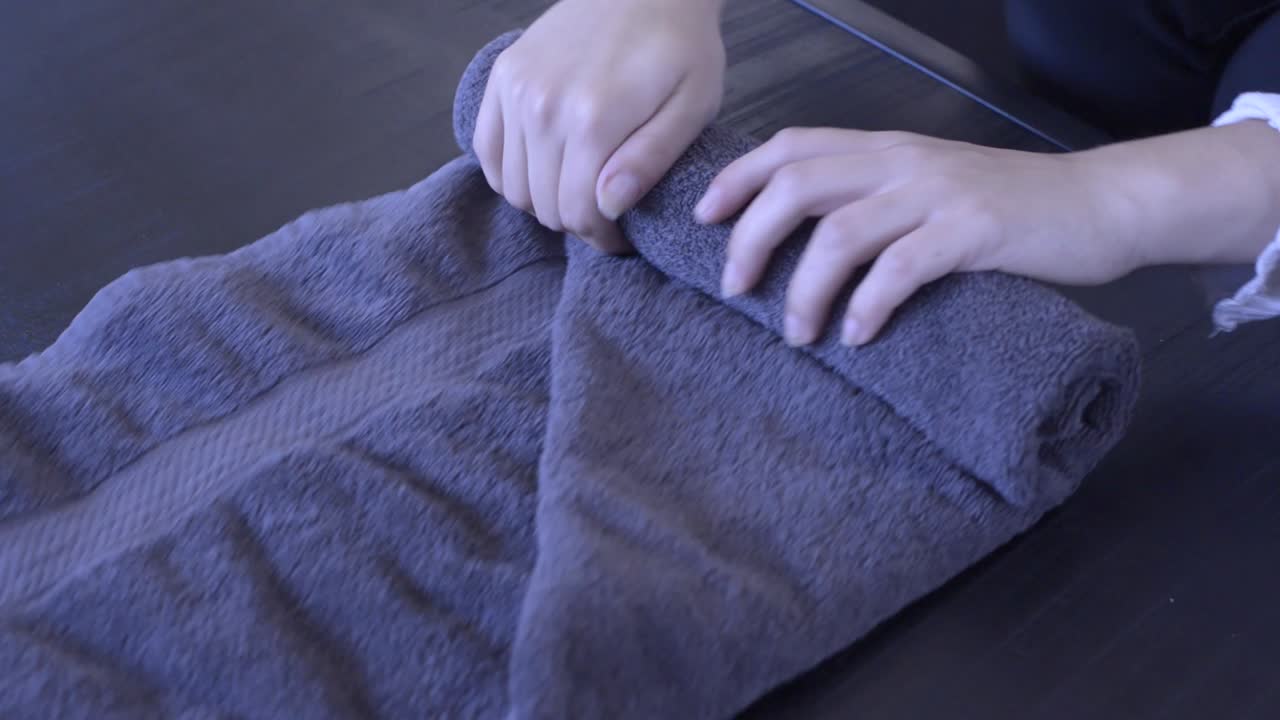 누군가 수건을 굴리고 모 ⁇ 이를 넣는 장면