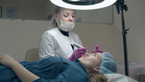 cosmetician talks to lady in dress against wall with mirror