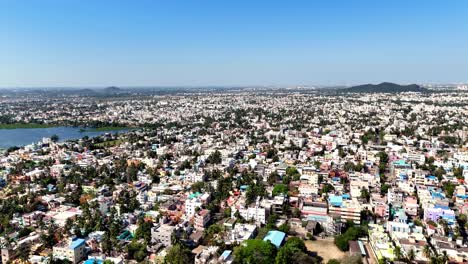 aerial view: a panoramic view of a vast urban landscape. the city extends far into the horizon, countless residential and commercial buildings densely packed together. glistening lake,