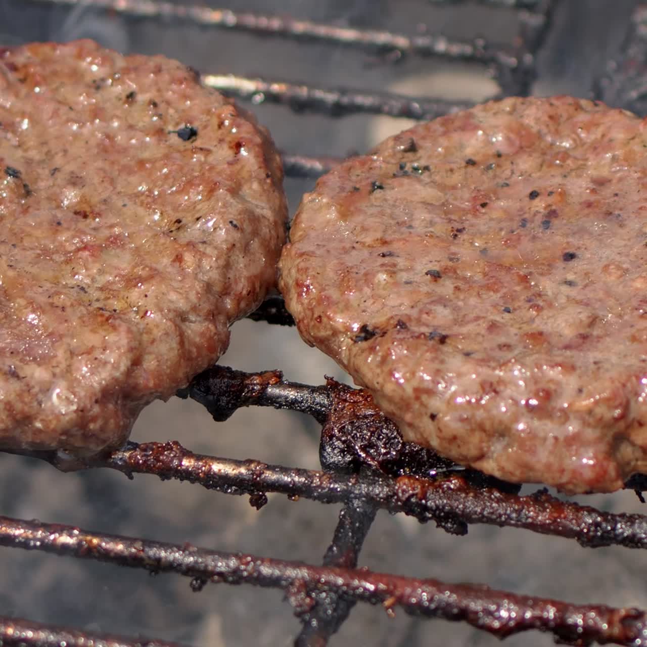 Tasty two hamburger meat frying on smoking hot barbecue  Slow motion video