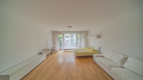 a modern studio apartment filled with natural light, featuring stylish white furniture