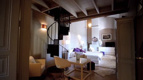 Slow-revealing-shot-of-a-master-bedroom-with-a-spiral-staircase-with-a-castle-in-France