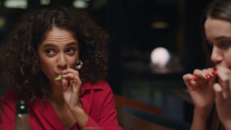 beautiful ladies eating lemon after drinking in bar. friends celebrate fun party