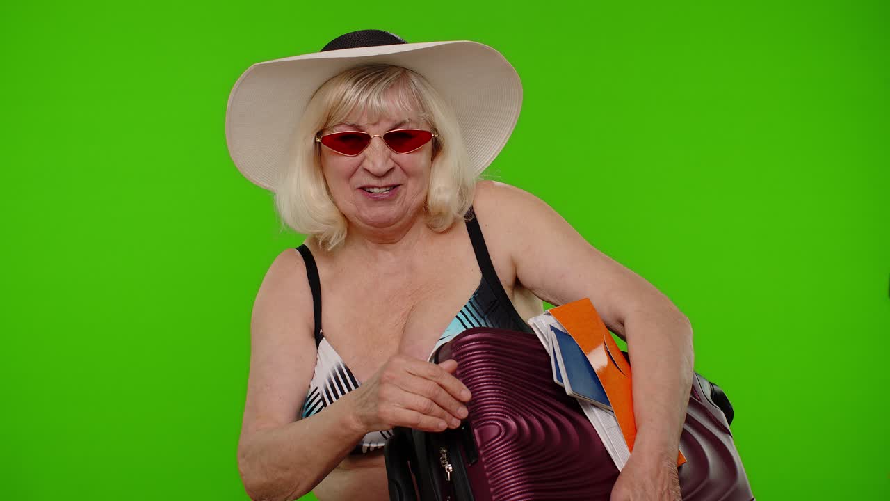 abuela anciana turista agitando la mano hola hola bienvenida, mujer con equipaje, pasaporte, boletos