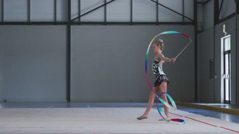 teenage female gymnast performing at sports hall