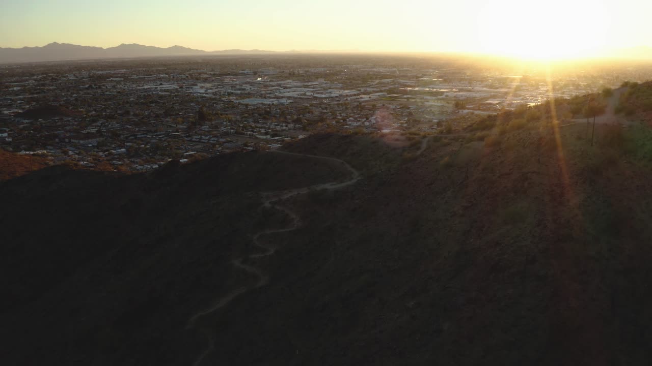 Sun peaks over mountain near southwestern city