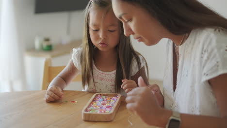 mother and daughter making jewelry