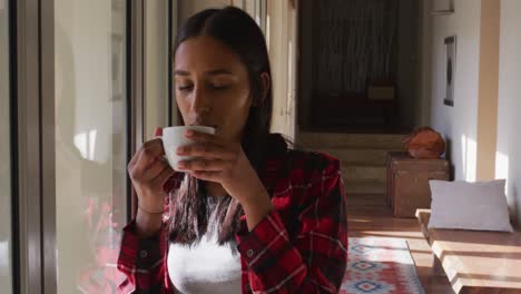 mujer de raza mixta bebiendo una taza de café
