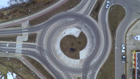 aerial: slowly rising above roundabout while motor vehicles enters and exits it