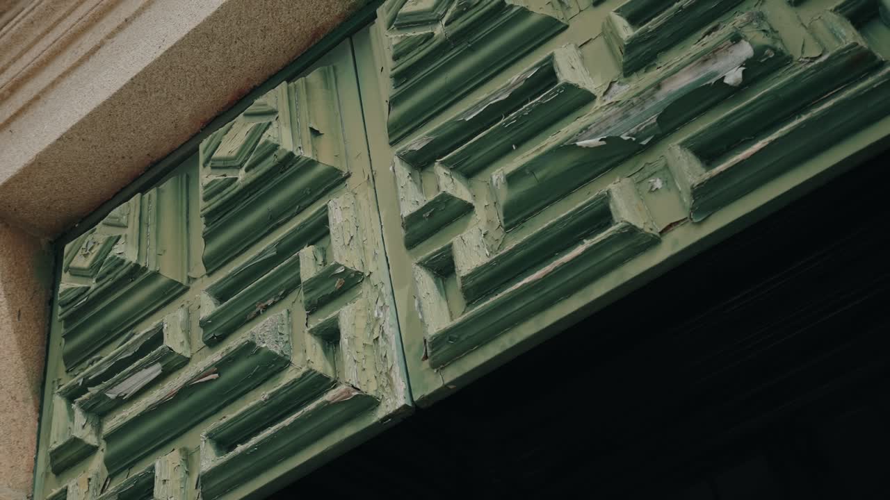 Detailed view of old green door with aged paint and carved texture