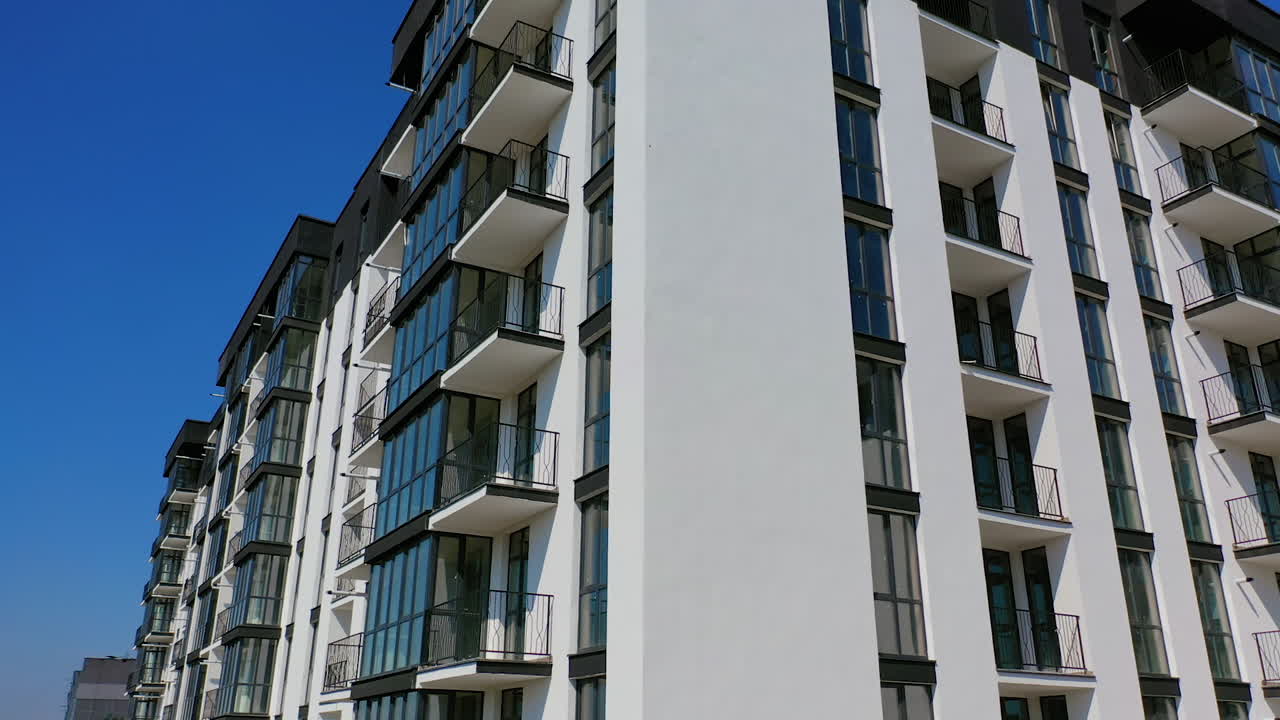 Newly built modern apartment building facade. Exterior of multi storey building. Modern design of urban architecture. Aerial view. Motion up.