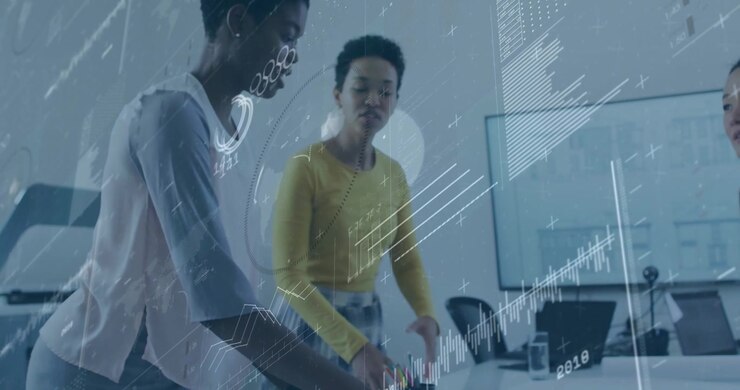 Presenter pointing at plans initiating charts with peer pointing at monitor in architecture review