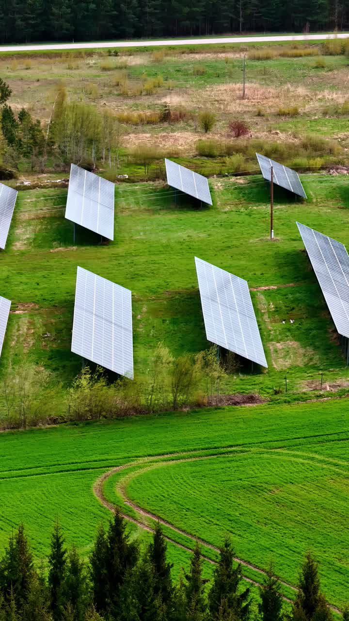 Solar panels in green fields, aerial drone vertical view
