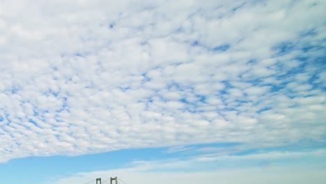 time lapse, hyperlapse, high stratus clouds streaming over puget sound and the tacoma narrows bridge, zoom out and pan left and down