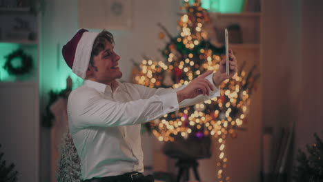 hombre feliz tomando selfies a través de la tableta en casa durante la navidad