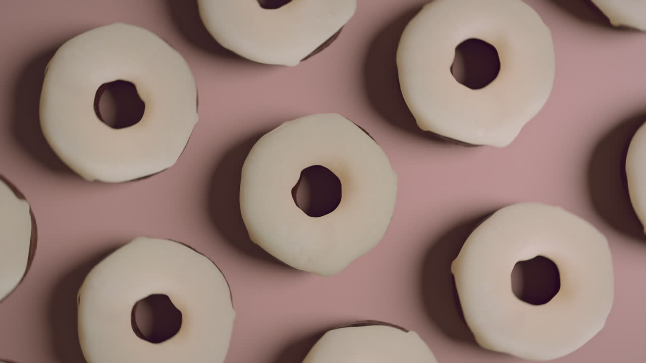 White glaze donuts on a light pink background
