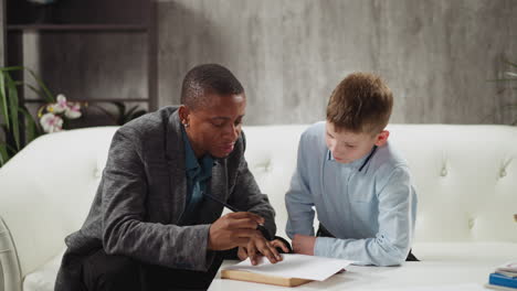hombre negro conduce una lección privada de inglés a un niño pequeño