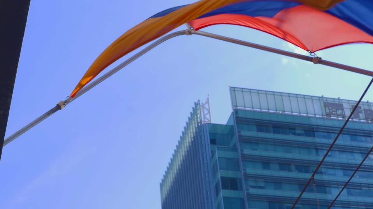 una bandera ondea al viento en un día ventoso en una ciudad ajetreada