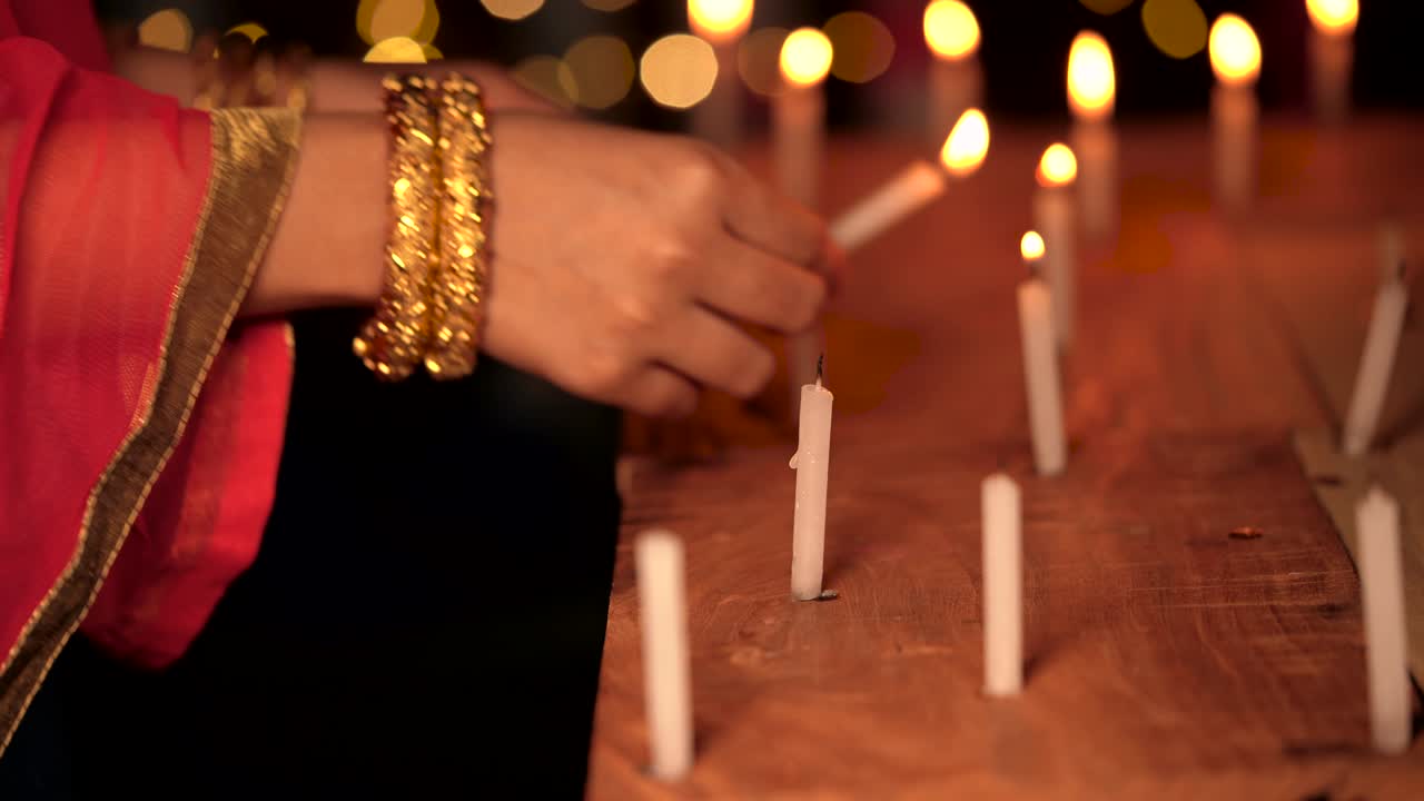 mujer encendiendo velas por la noche