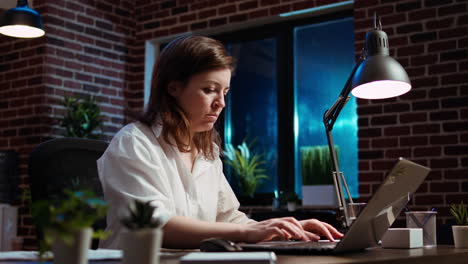 Businesswoman-researching-key-data-for-company-project-on-laptop