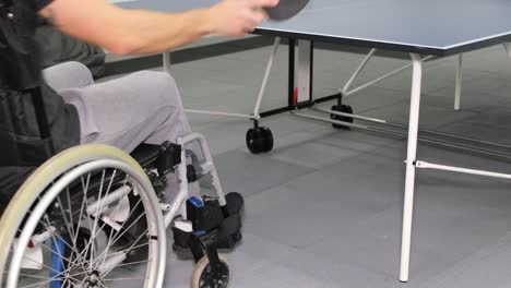 a man in a wheelchair plays table tennis sports excitement games with a racket a man in a wheelchair plays table tennis sports excitement games with a racket