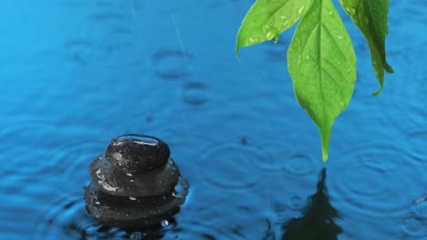 raindrops falling on a cairn and blue water.